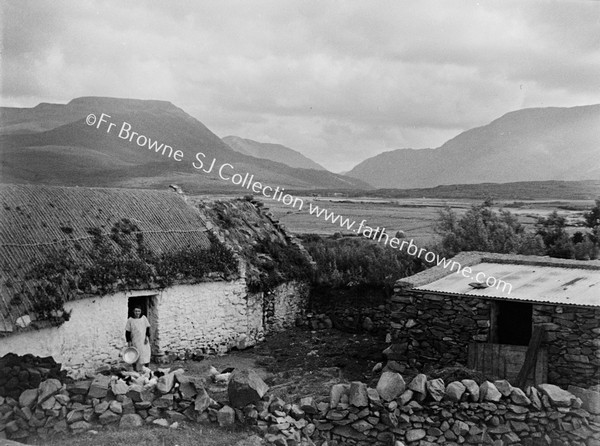 WOMAN AT COTTAGE DOORWAY